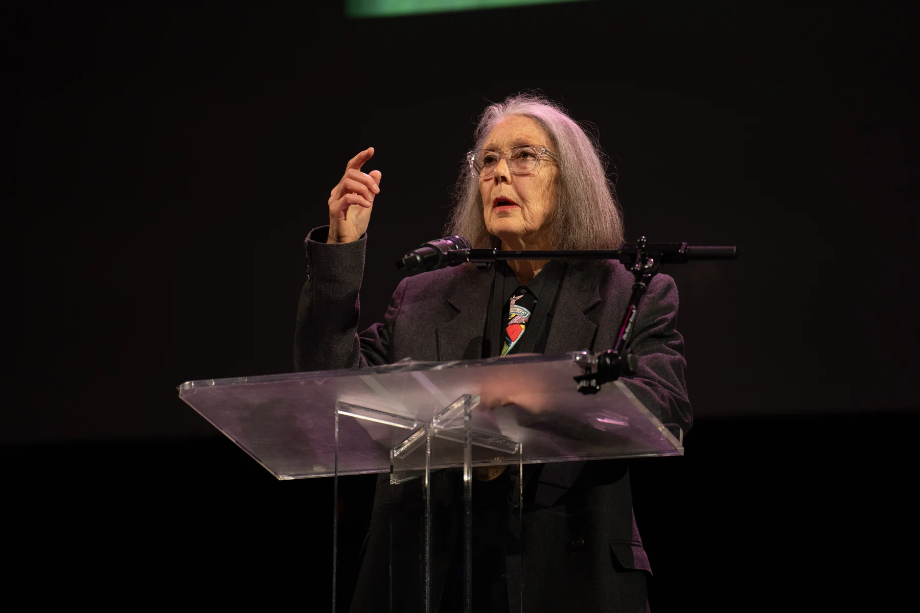 Anne Carson lit à un pupitre lors des lectures des finalistes des National Book Awards en 2024.