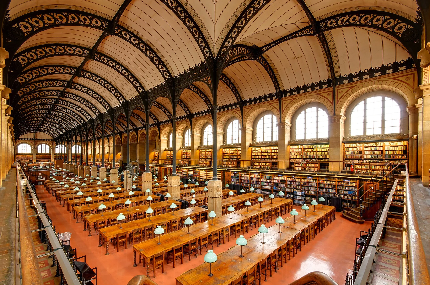 Salle de lecture de la bibliothèque Sainte-Geneviève sous ses grandes arches métalliques.