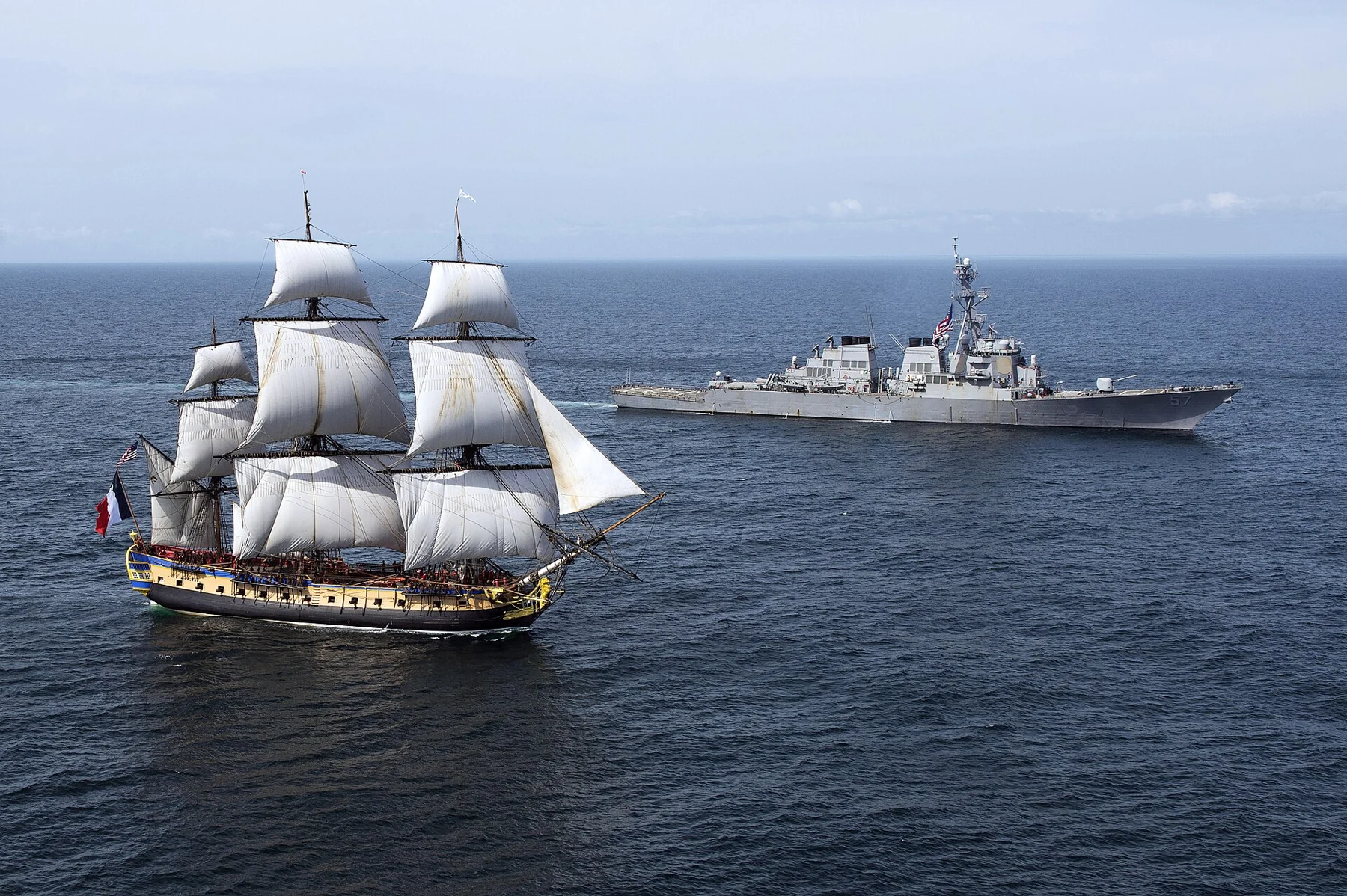 Le voilier Hermione et le destroyer USS Mitscher naviguent côte à côte.