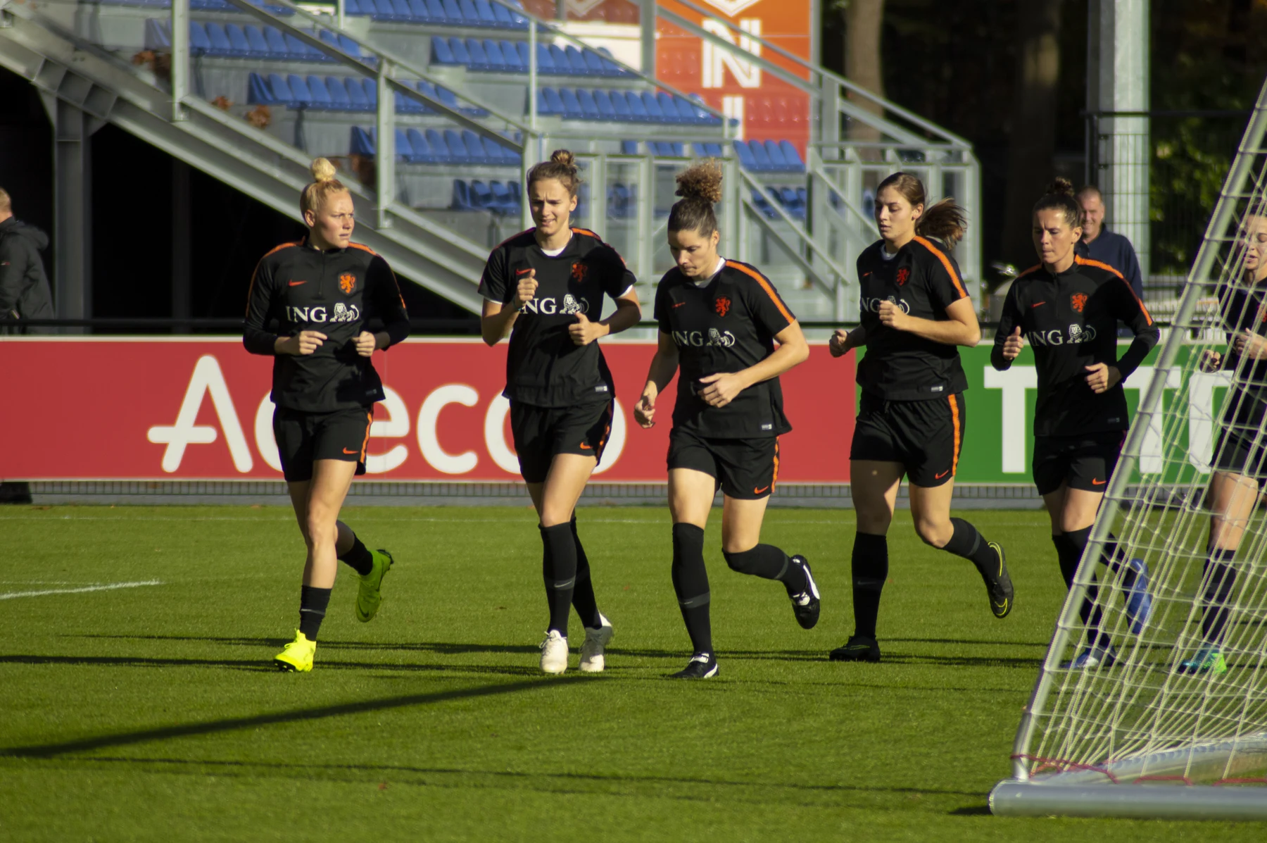 Joueuses de la sélection néerlandaise courant sur un terrain d’entraînement.