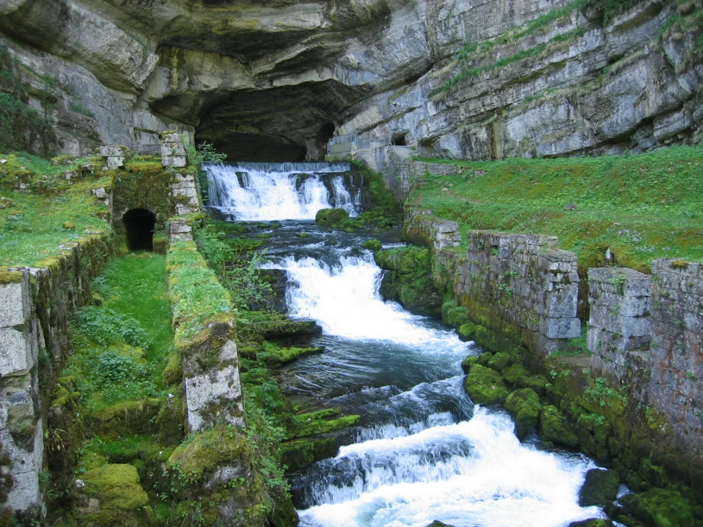Eau de la source de la Loue sortant d’une paroi rocheuse.