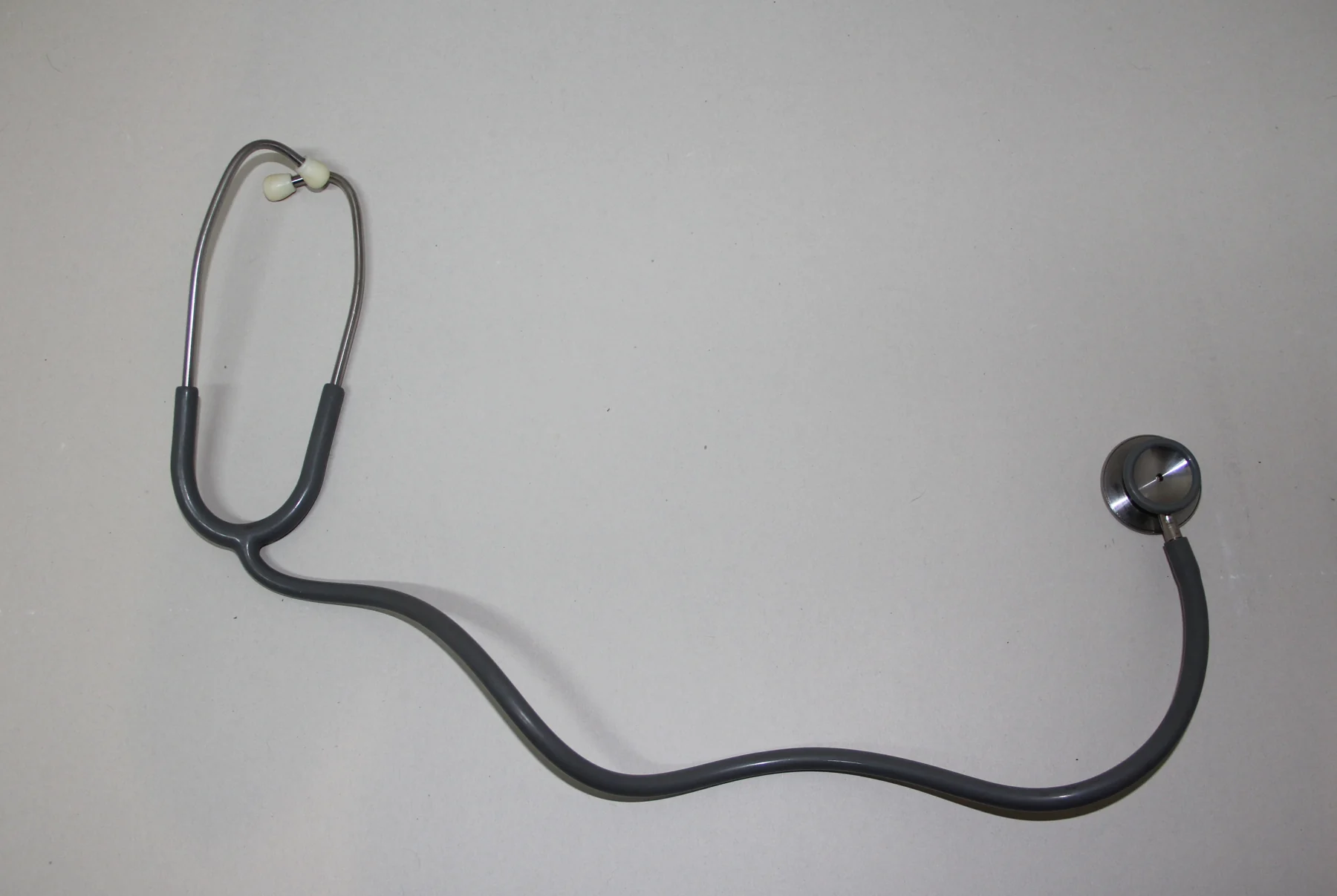 Stéthoscope noir posé sur un fond clair.