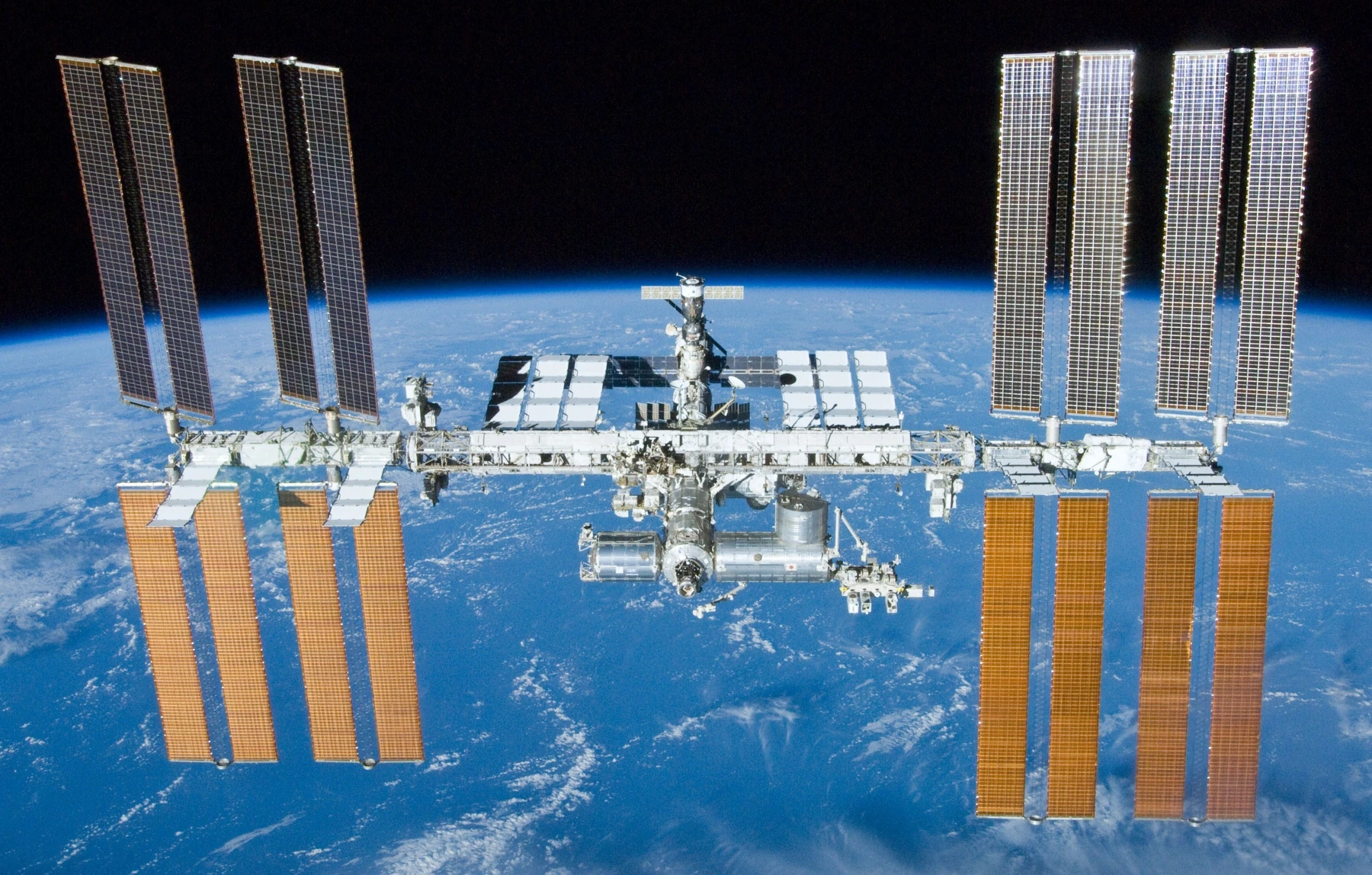 Station spatiale internationale et panneaux solaires au-dessus de la Terre.
